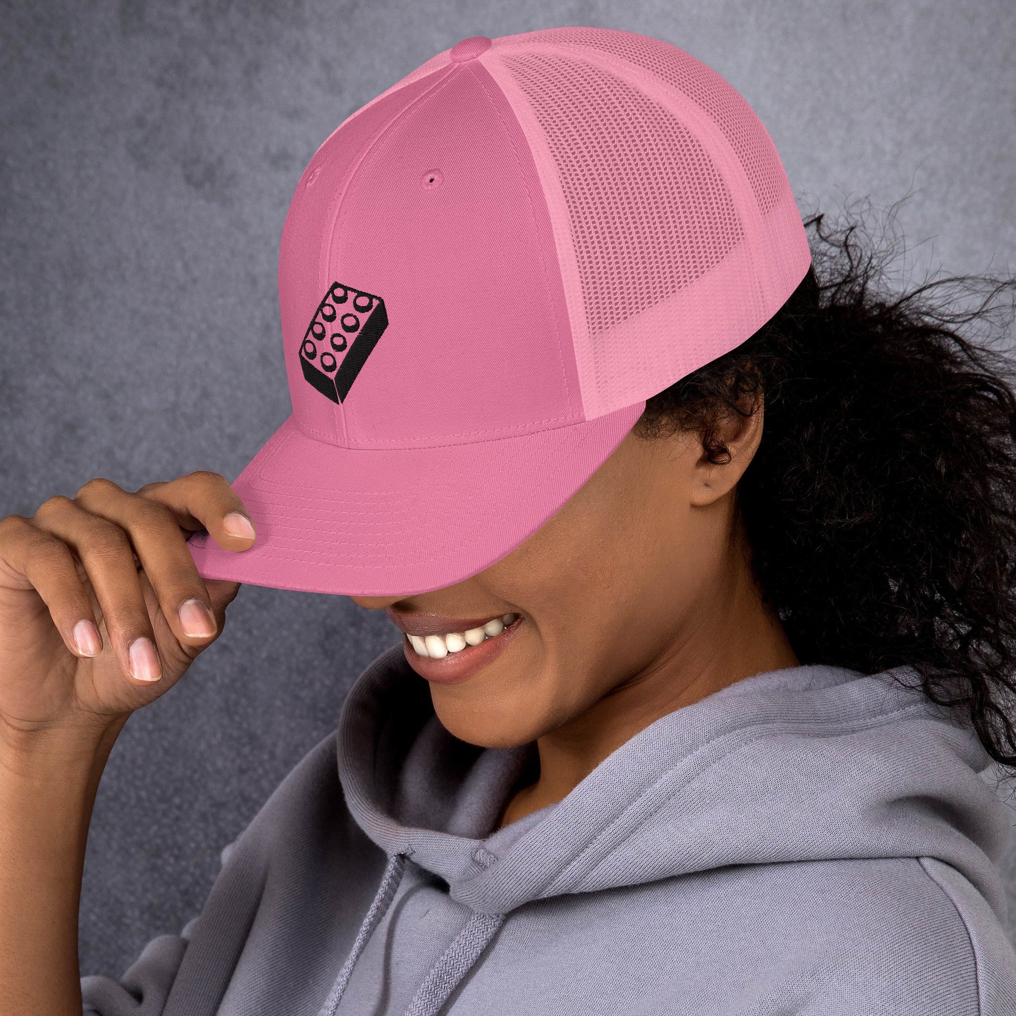 female model wearing an pink lego brick trucker hat